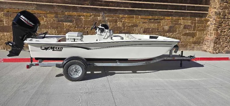 Slide: The Image of 2025 Mako Pro Skiff 15 CC boat on trailer, parked outdoors. - 1