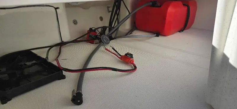 Slide: The Image of Interior view of a 2025 Mako Pro Skiff 15 CC boat with wiring and red fuel tank. - 21
