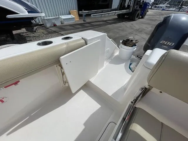 Slide: The Image of 2018 Pursuit 265 DC boat interior with open storage compartment and Yamaha 200 engine. - 12