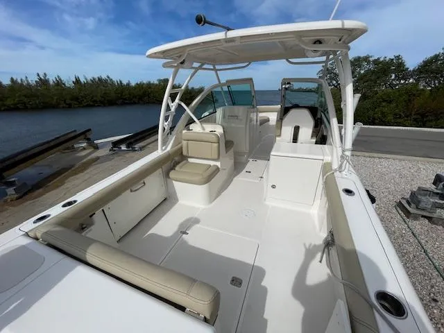 Slide: The Image of 2018 Pursuit 265 DC boat with spacious seating and sleek design by the water. - 14
