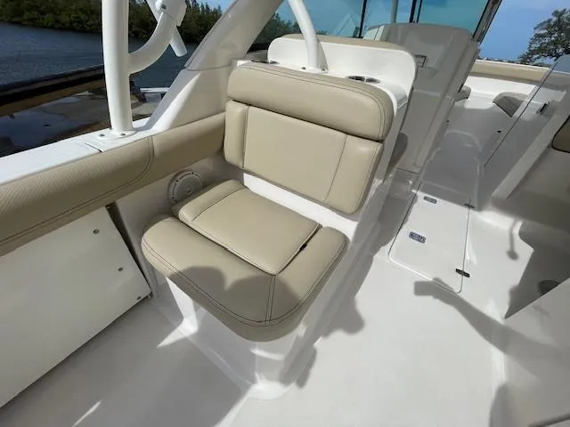 Slide: The Image of 2018 Pursuit 265 DC boat interior with beige seating and sleek design. - 17