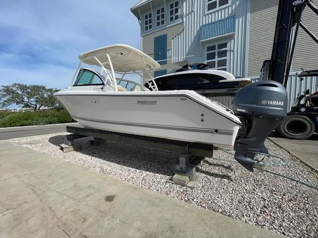 Slide: The Image of 2018 Pursuit 265 DC boat with Yamaha engine on display outdoors. - 2