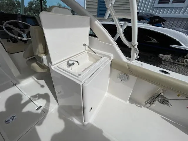 Slide: The Image of 2018 Pursuit 265 DC boat interior with open storage compartment and seating. - 28