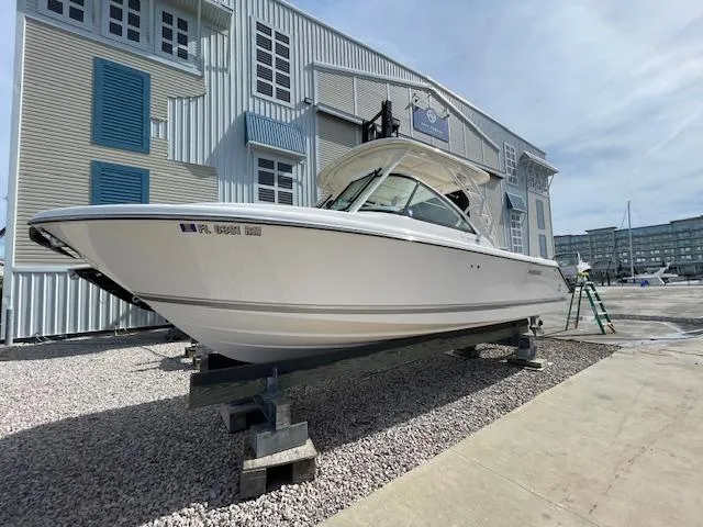 Slide: The Image of 2018 Pursuit 265 DC boat on display at a marina. - 3