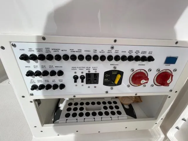 Slide: The Image of Control panel of a 2018 Pursuit 265 DC boat with various switches and dials. - 30