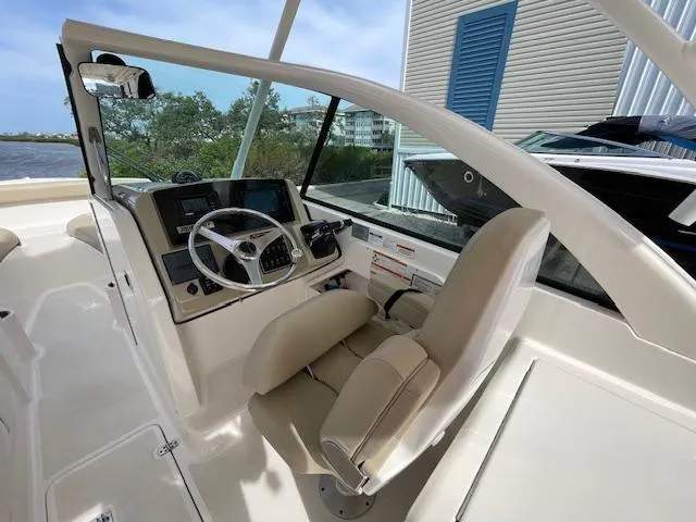 Slide: The Image of 2018 Pursuit 265 DC boat cockpit with steering wheel and controls. - 31