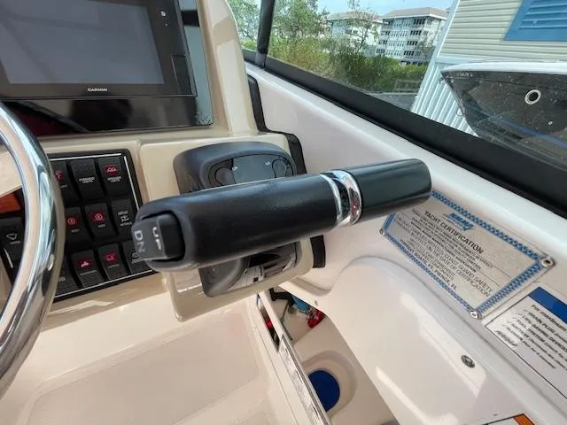 Slide: The Image of Control panel of a 2018 Pursuit 265 DC boat with steering and switches. - 33