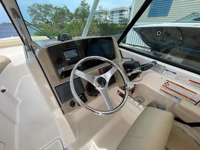 Slide: The Image of 2018 Pursuit 265 DC boat cockpit with steering wheel and navigation controls. - 36