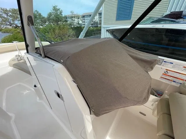 Slide: The Image of 2018 Pursuit 265 DC boat interior with covered console and seating area. - 37