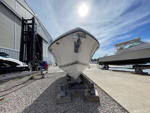 Slide: The Image of 2018 Pursuit 265 DC boat on dry dock under a bright sky. - 4