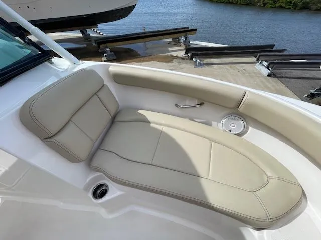 Slide: The Image of 2018 Pursuit 265 DC boat with beige seating, docked by the water. - 42