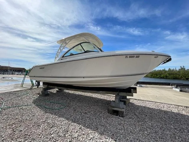 Slide: The Image of 2018 Pursuit 265 DC boat on dry dock under blue sky. - 5