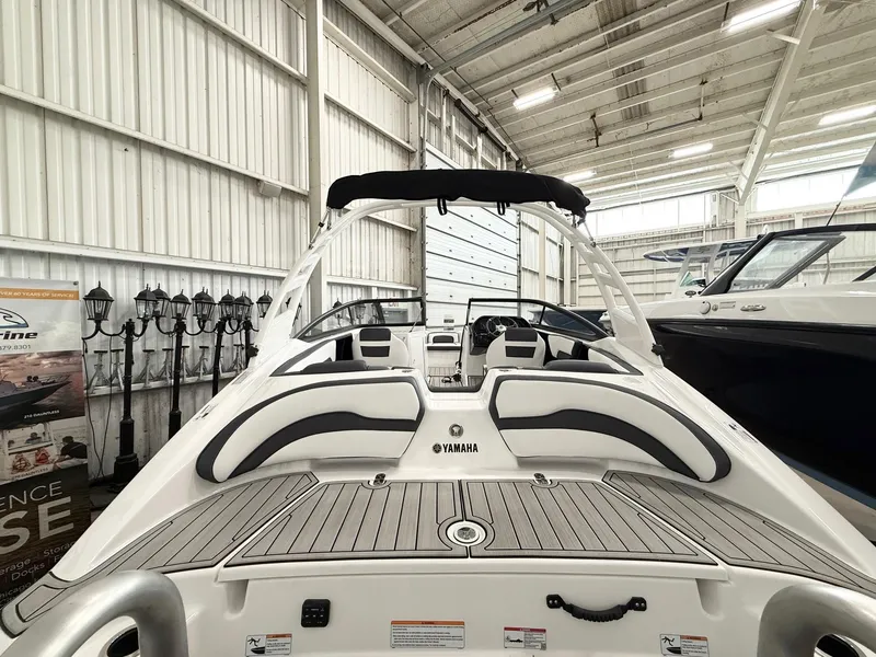Slide: The Image of 2025 Yamaha Boats 195S in showroom, featuring sleek design and spacious seating. - 2