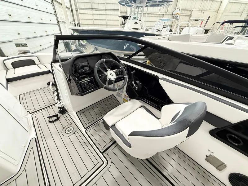 Slide: The Image of 2025 Yamaha Boats 195S interior with sleek design and modern dashboard in a showroom setting. - 3