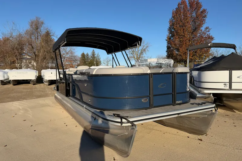 Slide: The Image of 2025 Crest Classic 220 pontoon boat with canopy, parked outdoors on a sunny day. - 15