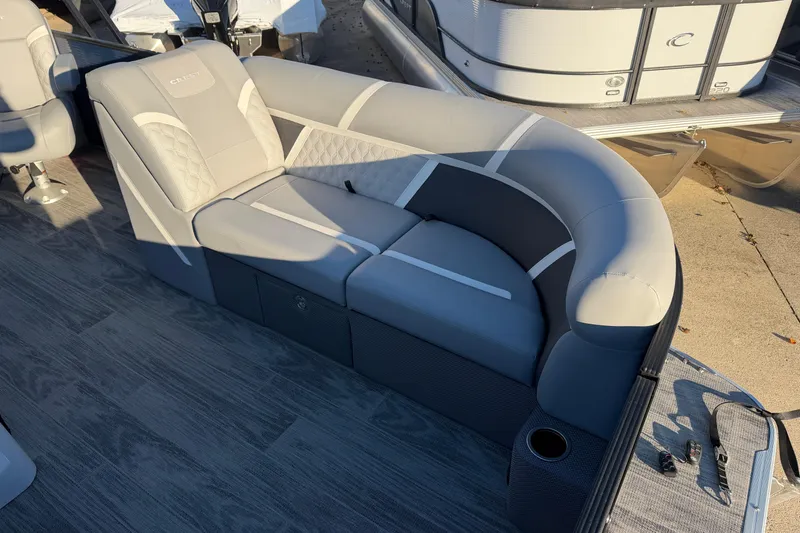 Slide: The Image of 2025 Crest Classic 220 boat interior with gray cushioned seating and cup holder. - 17