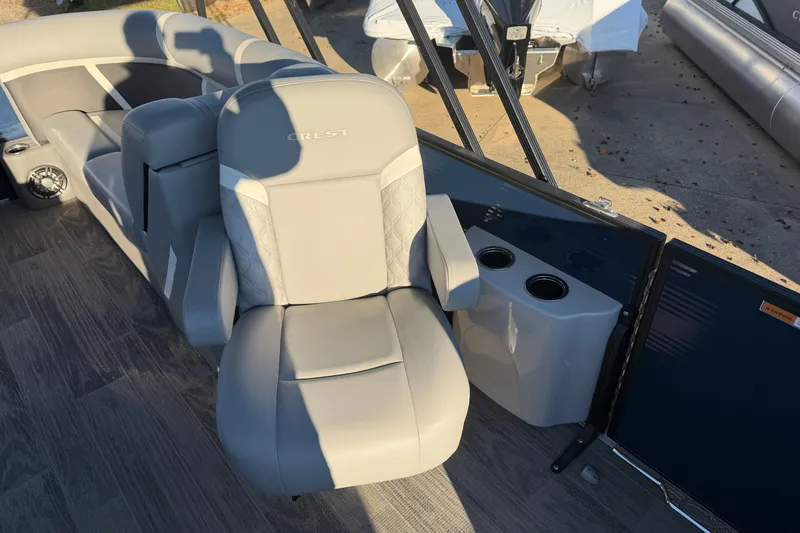 Slide: The Image of 2025 Crest Classic 220 boat interior with gray captain's chair and cup holders. - 24