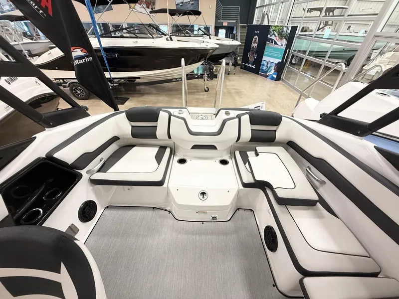 Slide: The Image of 2025 Yamaha Boats AR195 interior with sleek seating and modern design in a showroom. - 4