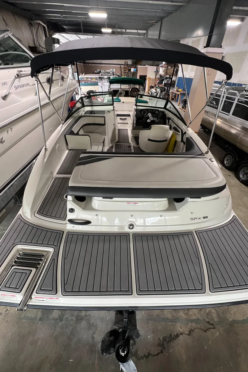 Slide: The Image of 2017 Sea Ray SPX 190 boat with spacious deck and canopy in showroom. - 4