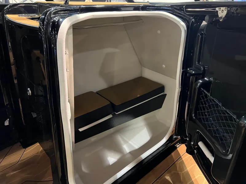 Slide: The Image of 2025 Yamaha Boats 255XD interior storage compartment with cushioned seating. - 6