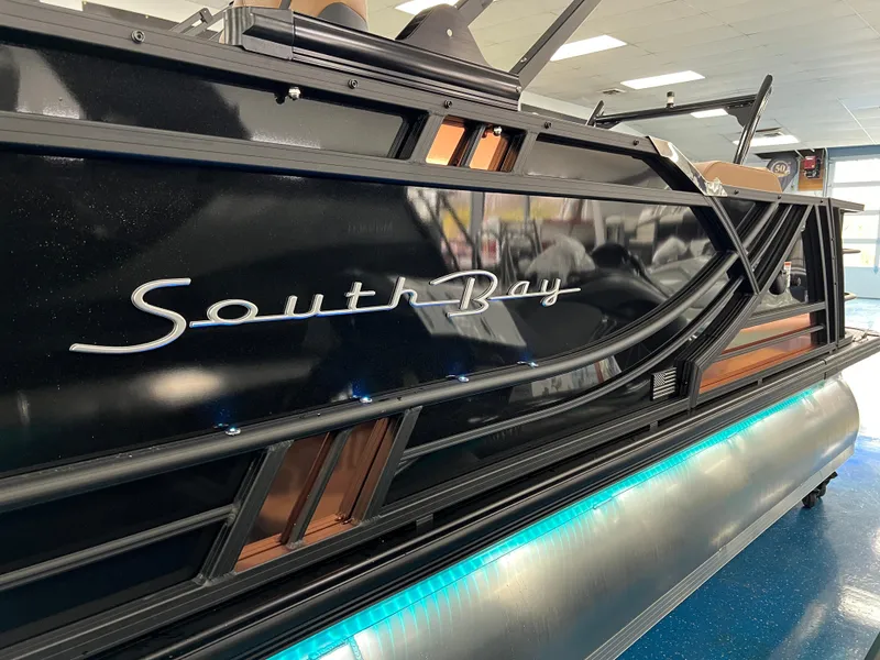 Slide: The Image of 2025 South Bay 523 ULE 3.0+ pontoon boat with sleek black design and illuminated accents. - 36