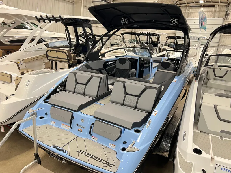 Slide: The Image of 2025 Yamaha Boats 255XD, sleek design, luxury seating, showcased in a boat showroom. - 5