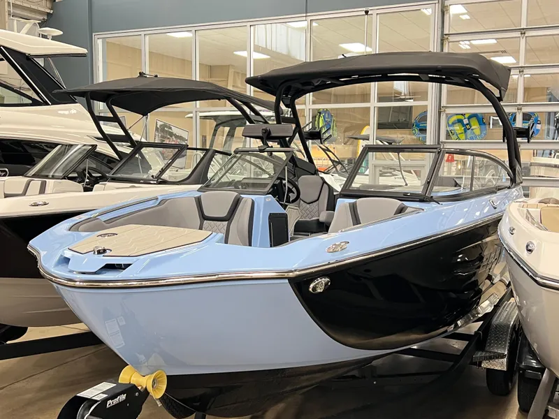 Slide: The Image of 2025 Yamaha Boats 255XD in showroom, sleek design with black and blue exterior. - 6