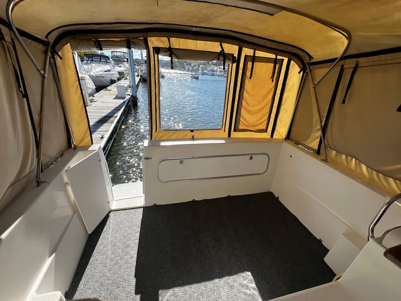 Slide: The Image of Interior view of 1995 Bayliner 2859 Classic Cruiser with tan canopy and marina backdrop. - 10