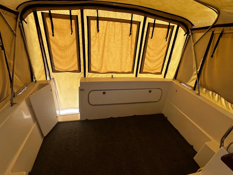 Slide: The Image of Interior of 1995 Bayliner 2859 Classic Cruiser with enclosed canopy and carpeted floor. - 11