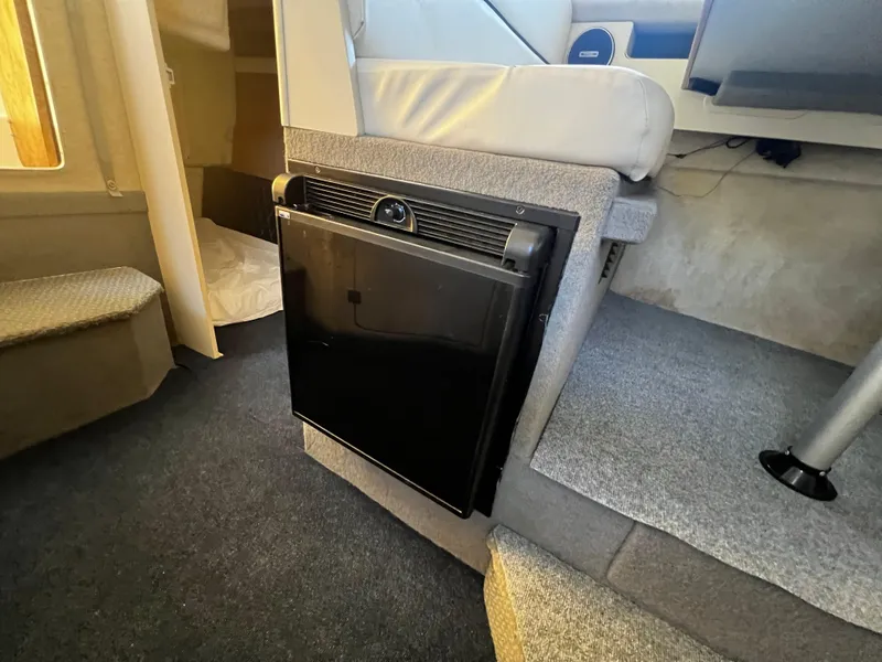 Slide: The Image of Interior of 1995 Bayliner 2859 Classic Cruiser with compact fridge and seating area. - 17