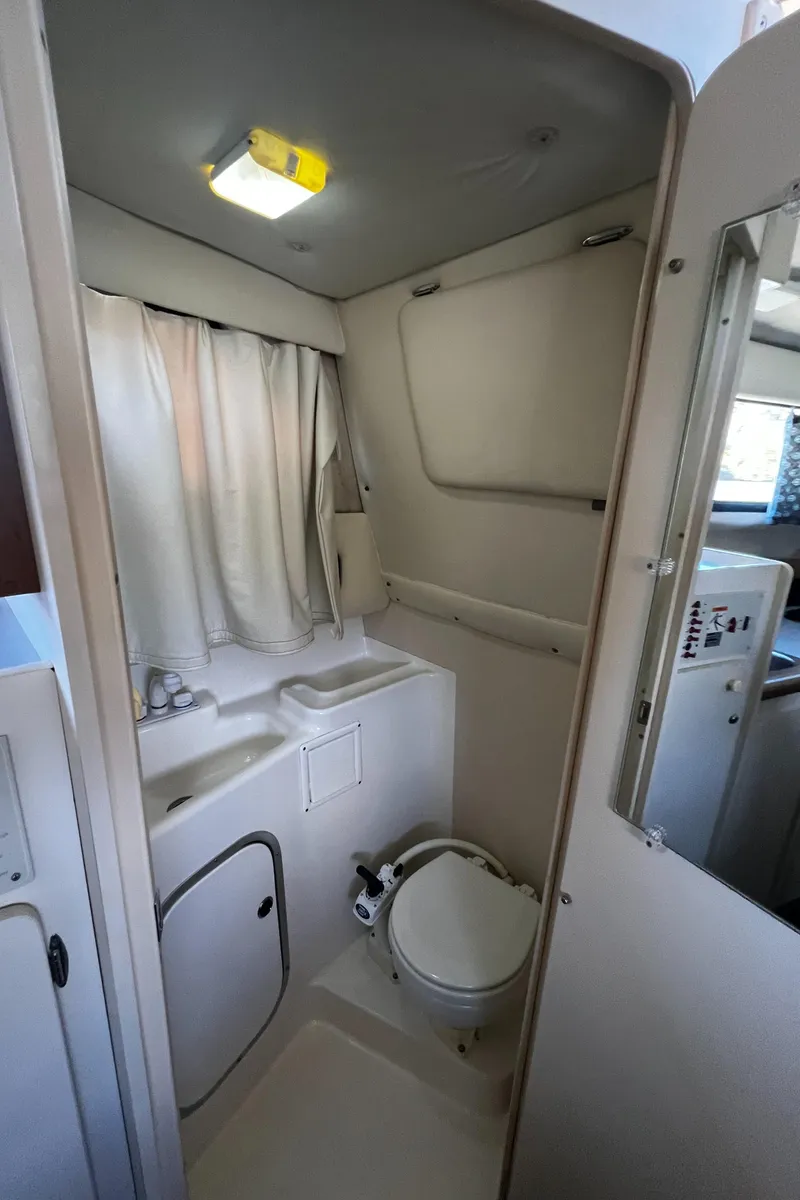 Slide: The Image of 1995 Bayliner 2859 Classic Cruiser bathroom with sink, toilet, and shower curtain. - 19