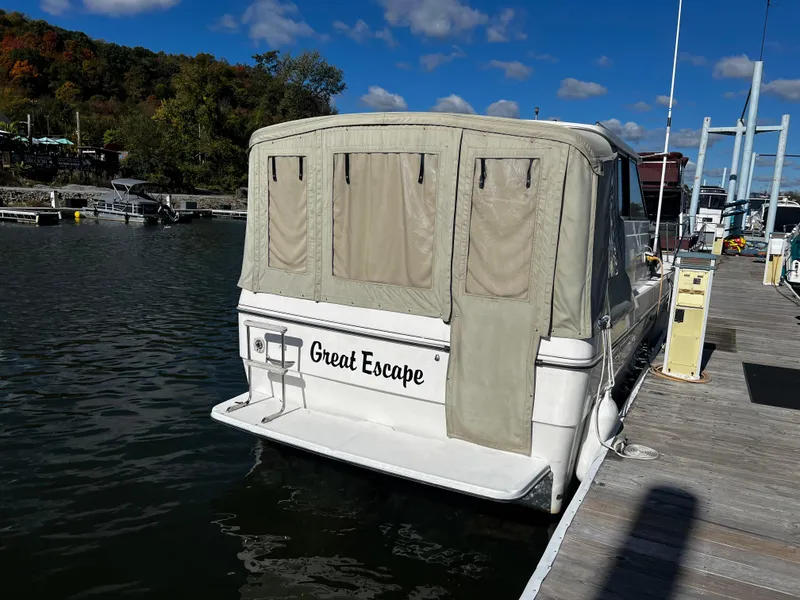 Slide: The Image of 1995 Bayliner 2859 Classic Cruiser docked, named "Great Escape," with beige canopy. - 3