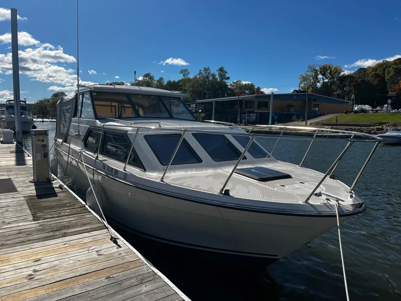Slide: The Image of 1995 Bayliner 2859 Classic Cruiser docked at marina under clear blue sky. - 4