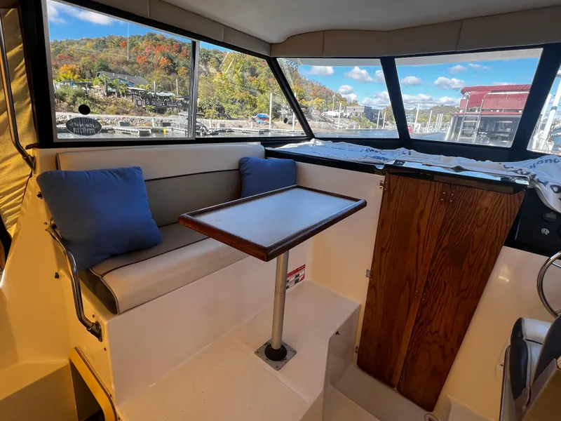 Slide: The Image of Interior of 1995 Bayliner 2859 Classic Cruiser with seating and table, scenic marina view. - 8