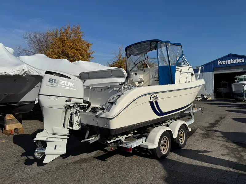 Slide: The Image of 1998 Cobia 220 Walkaround boat with Suzuki outboard motor on trailer. - 2