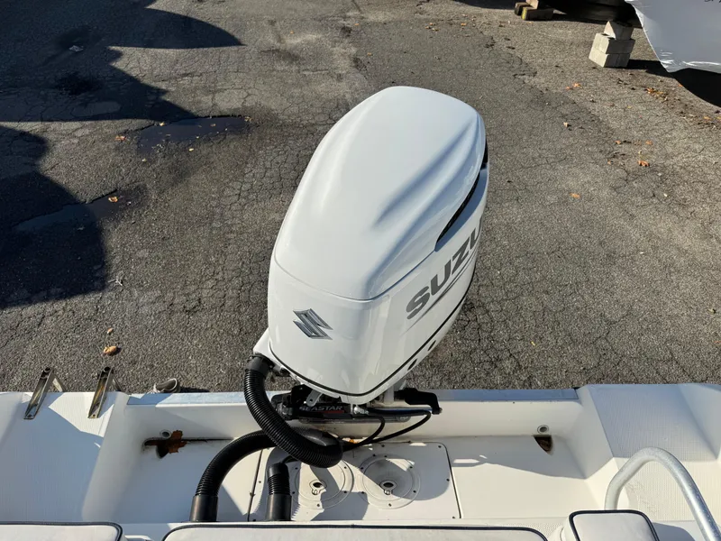 Slide: The Image of 1998 Cobia 220 Walkaround with Suzuki outboard motor on a paved surface. - 4