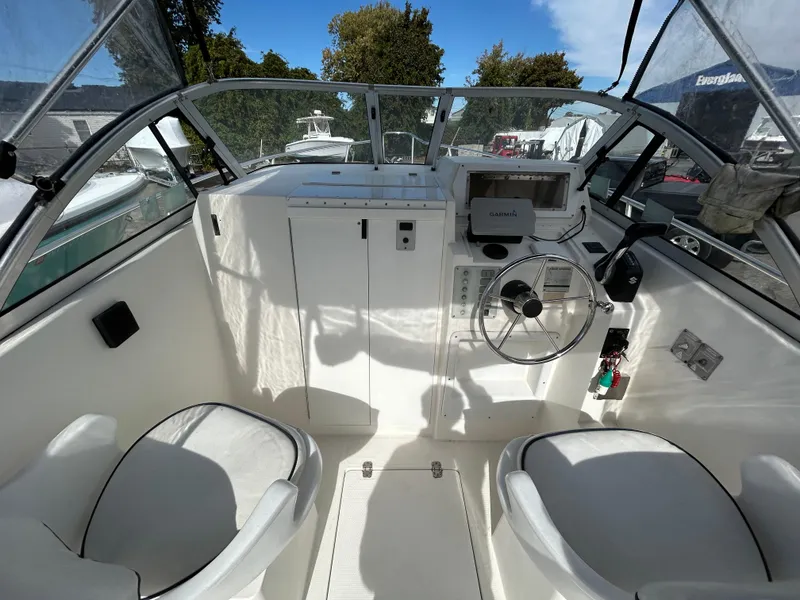 Slide: The Image of 1998 Cobia 220 Walkaround boat interior with steering wheel and seating. - 5
