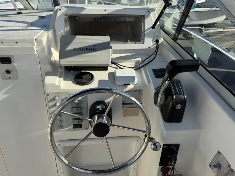 Slide: The Image of 1998 Cobia 220 Walkaround boat helm with Garmin GPS and steering wheel. - 6