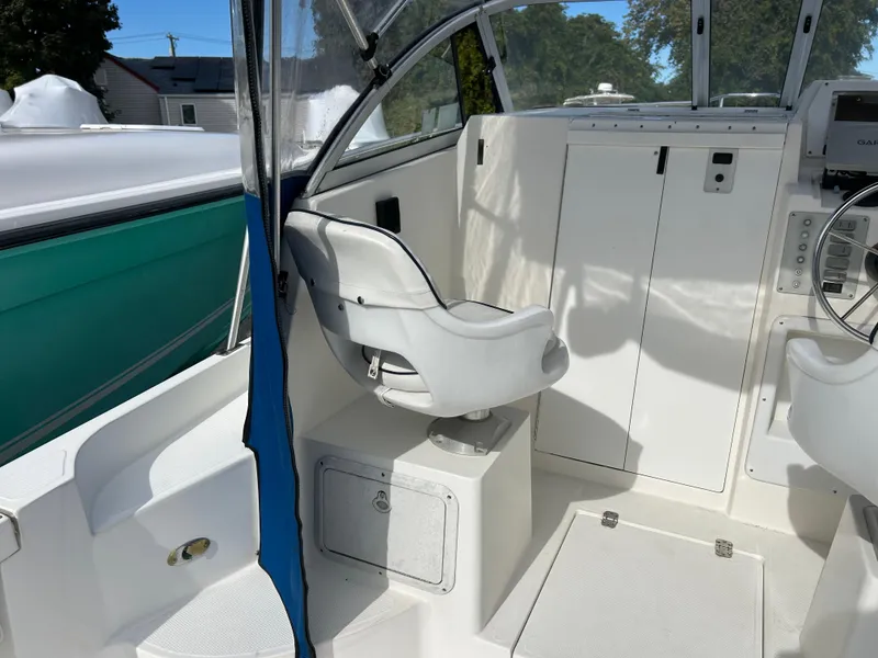 Slide: The Image of 1998 Cobia 220 Walkaround boat interior with captain's chair and control panel. - 8