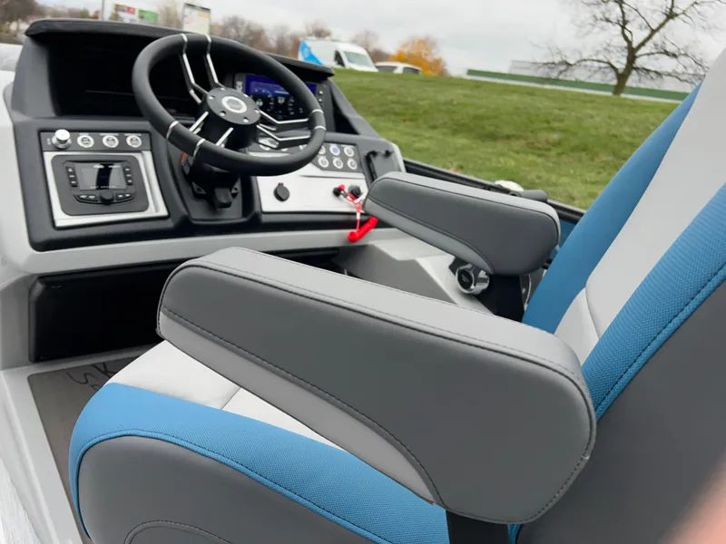 Slide: The Image of 2025 South Bay 523 RS3 3.0+ boat interior with steering wheel and blue-gray seating. - 33