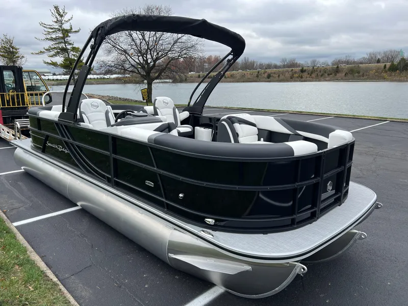 Slide: The Image of 2025 South Bay S224 RS 3.0 Hybrid Arch pontoon boat by a lake. - 3