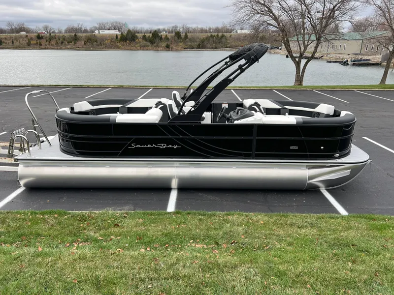 Slide: The Image of 2025 South Bay S224 RS 3.0 Hybrid Arch pontoon boat parked near a lake. - 4