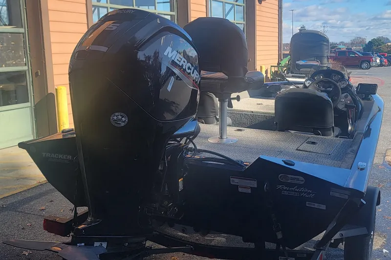 Slide: The Image of 2021 Tracker Pro Team 175 TF boat with Mercury engine, parked outside a building. - 2