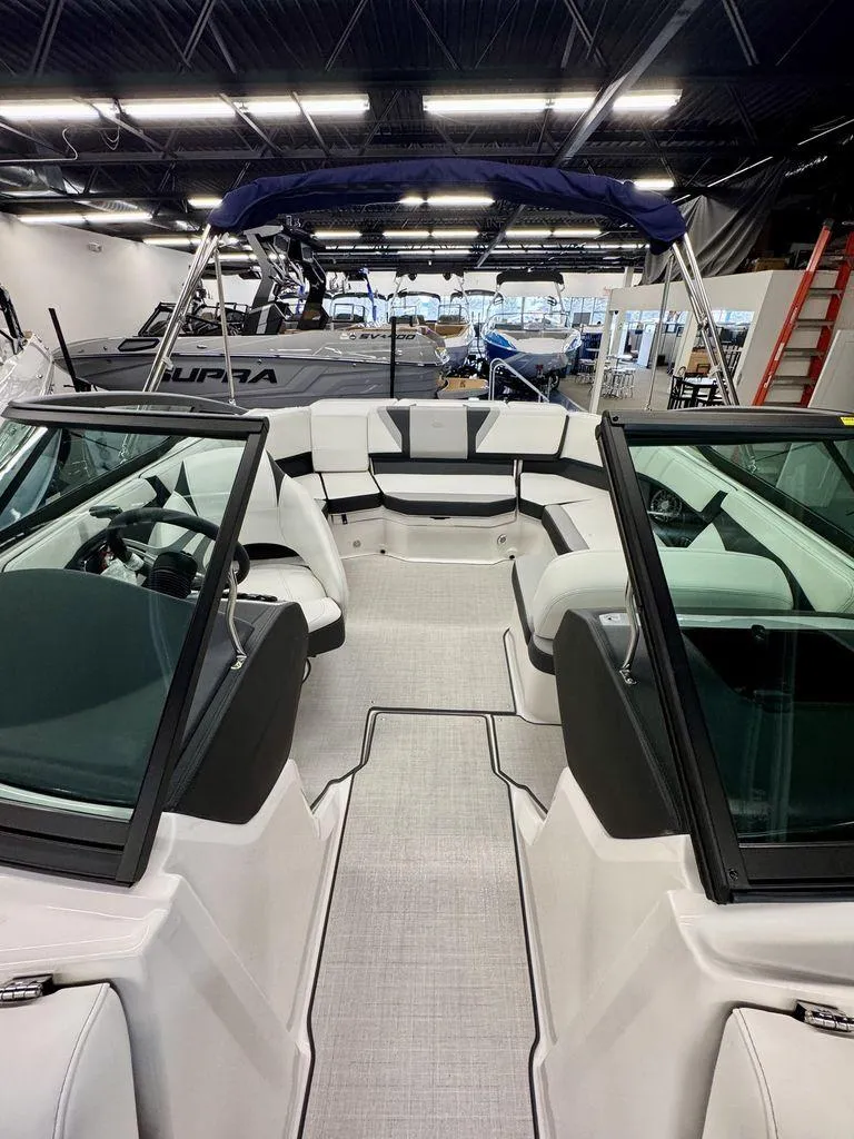 Slide: The Image of 2025 Regal 2000 ES boat interior with sleek seating and modern design in showroom. - 13