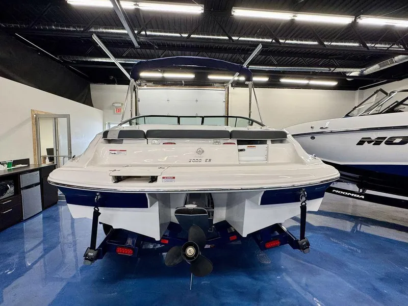 Slide: The Image of 2025 Regal 2000 ES boat in showroom, rear view with propeller and seating. - 2