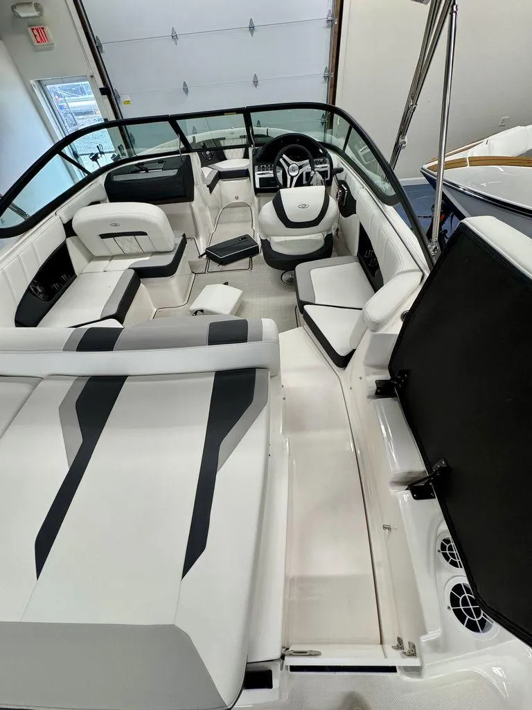 Slide: The Image of 2025 Regal 2000 ES boat interior with modern seating and steering wheel in a showroom. - 5