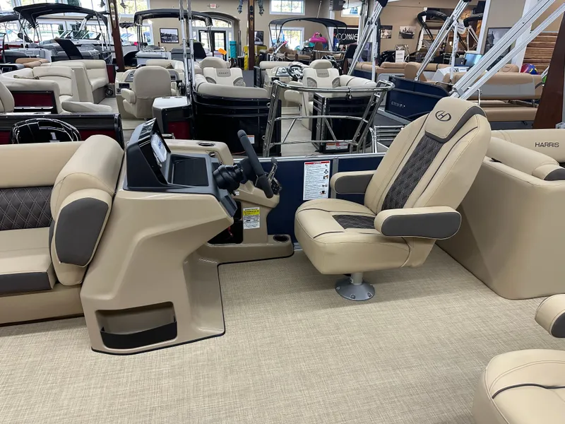 Slide: The Image of 2024 Harris Sunliner 230 boat interior with beige captain's chair and steering console. - 5