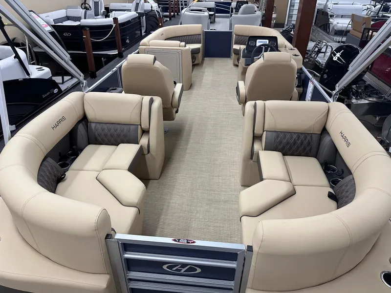 Slide: The Image of 2024 Harris Sunliner 230 pontoon boat with beige seating and spacious interior layout. - 9