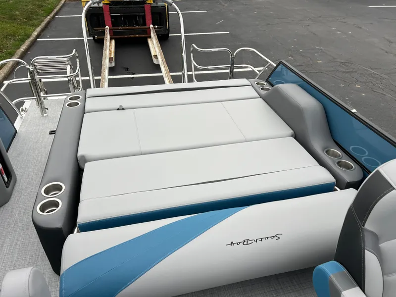 Slide: The Image of 2025 South Bay S224UL boat interior with gray and blue seating and cup holders. - 15