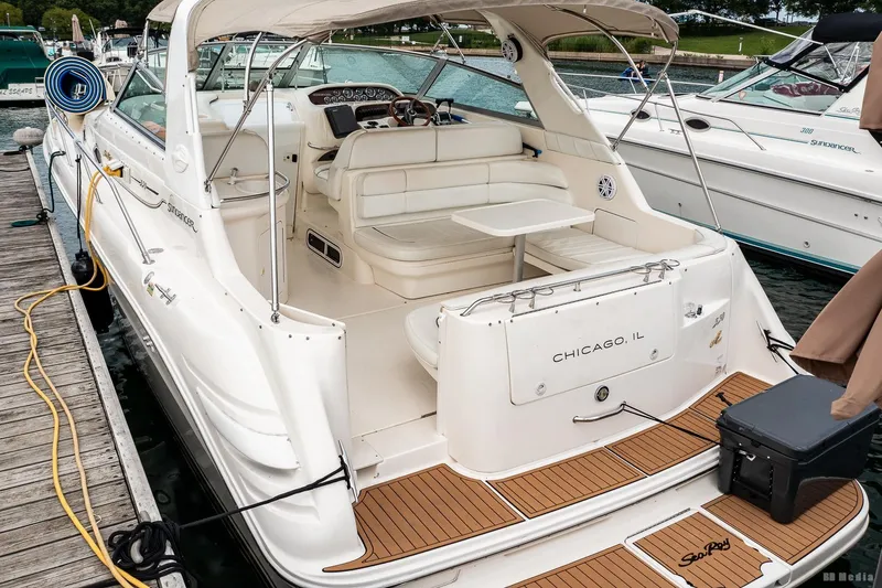 Slide: The Image of 1998 Sea Ray 330 Sundancer docked, featuring spacious seating and elegant design. - 11